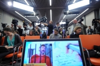 Moscow : Journalists sit near a screen displaying convicted Russian arms smuggler Viktor Bout in Moscow, on April 12, 2012, during a teleconference with Bout from his US prison. The unusual teleconference involved a video link between Moscow and a New York City studio from which Bout’s wife Alla and lawyers arranged a direct five-minute phone conversation with the convicted arms smuggler in his Brooklyn prison. Source: AFP / East News
