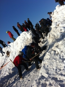 The Expedition teams help the priests overcome a snow mound. Source: Artem Zagorodnov