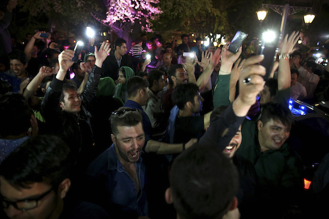 Iranians celebrate a framework agreement on Iran's nuclear program between their country and six world powers, in a street in Tehran, Iran, Friday, April 3, 2015. (AP Photo/Vahid Salemi)