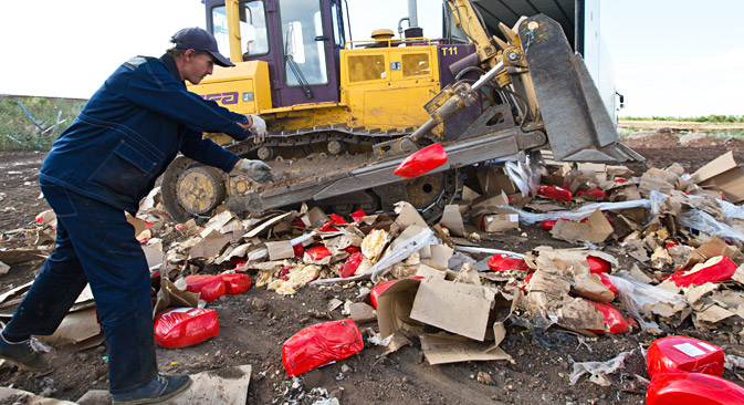 	A bulldozer crushes illegally imported cheese at a landfill near the village of Podgorodnyaya Prokrovka, Orenburg Region, Aug.7, 2015. Source: Sergei Medvedev/TASS